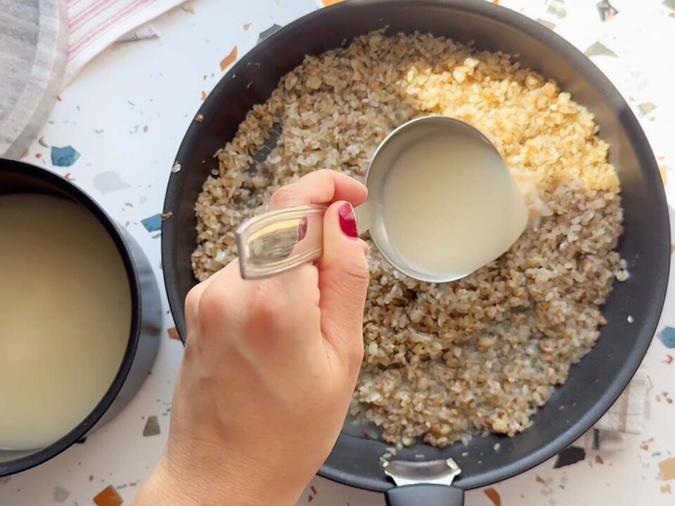 Añadir caldo a Risotto de hongos y parmesano