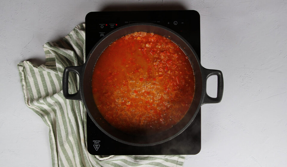 Añadir mitad del caldo a Arroz con cangrejo azul