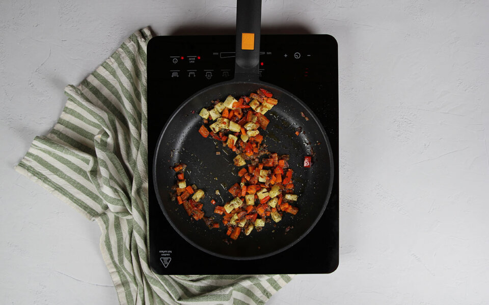 Añadir especias a quinoa con verduras y huevo