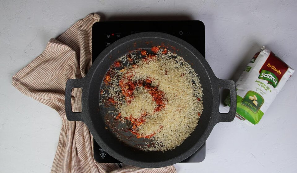 Hacer sofrito y echar el arroz en Arroz con alcachofas y pollo