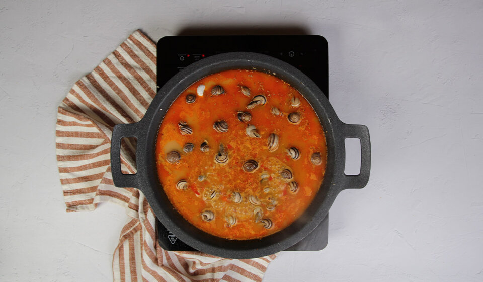 Incorporar caldo en Arroz con caracoles