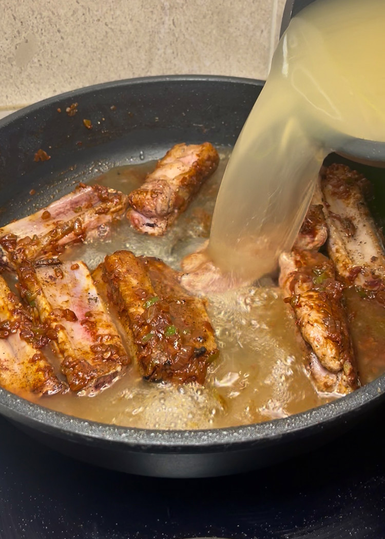 Verter caldo a arroz al horno con costillas