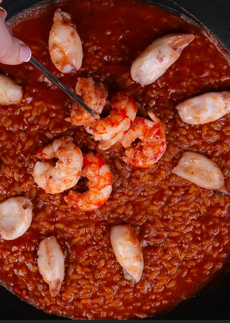 Colocar marisco en paella con salmorreta